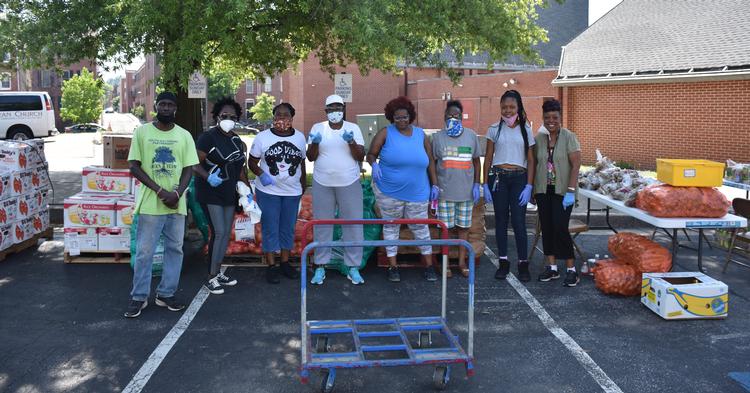 South Baltimore Partnership volunteers prepare to distribute fresh meat and produce to neighbors during the COVID-19 pandemic using a Baltimore Community ToolBank cart. 